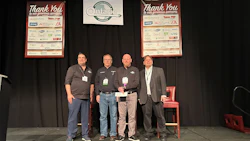 Four professionals on stage at Ontario conference with sponsor recognition boards