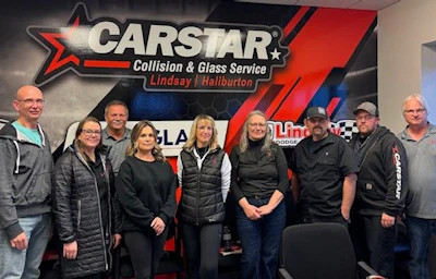 CARSTAR Collision & Glass Service team photo with company logo backdrop