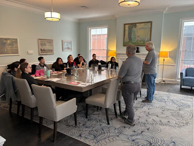 Business meeting in conference room with group seated at large table