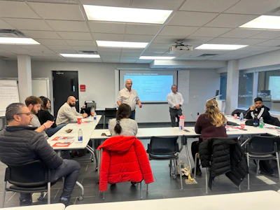 Professional training session with participants seated in classroom with two presenters