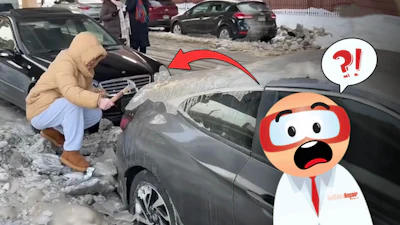 Person in yellow coat examining damaged car amid road debris and snow
