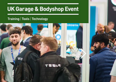 Professionals networking at UK Garage & Bodyshop Event with Tesla staff