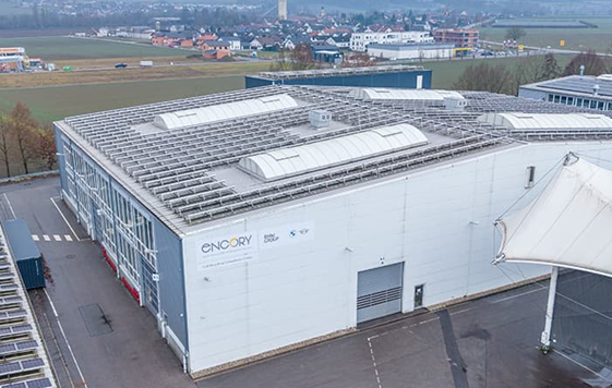 White industrial building with solar panels, aerial view of modern facility
