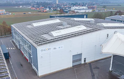 White industrial building with solar panels, aerial view of modern facility