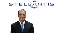 Professional headshot of male executive in dark suit with blue tie, Stellantis logo visible above