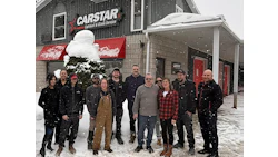 CARSTAR collision repair team standing outside snowy shop in winter