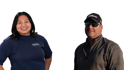 Two employees in company shirts, smiling and wearing professional attire