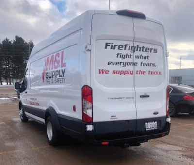 White delivery van for M&L Supply with firefighter equipment messaging