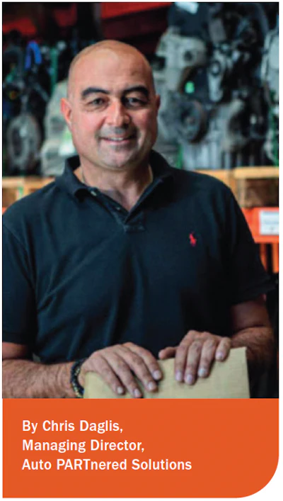 Smiling professional in black polo shirt standing in workshop with machinery background