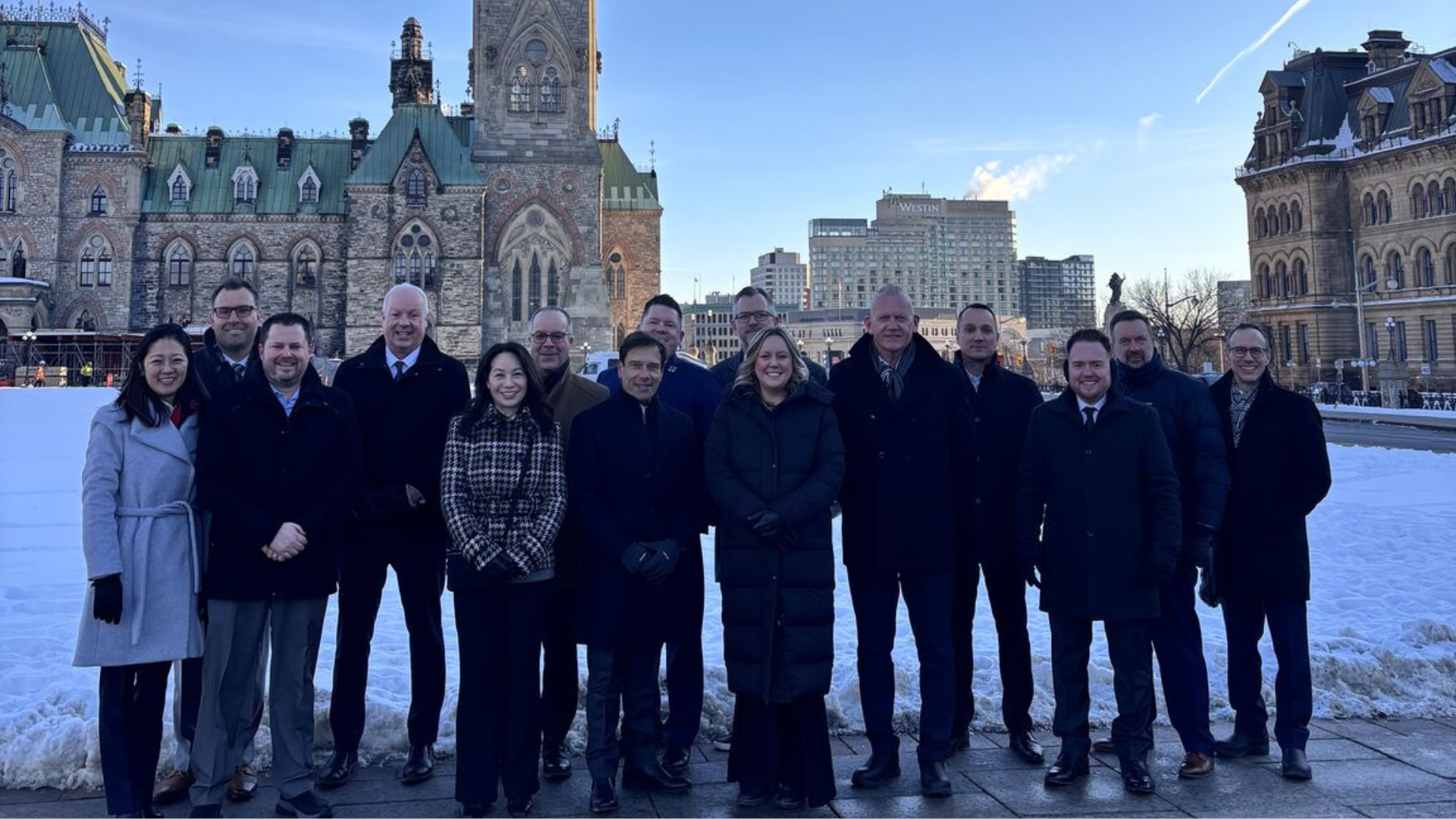 Group of professionals standing in winter outside Canadian Parliament buildings in Ottawa