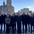 Group of professionals standing in winter outside Canadian Parliament buildings in Ottawa