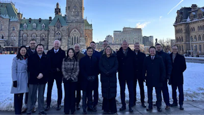 Group of professionals standing in winter outside Canadian Parliament buildings in Ottawa