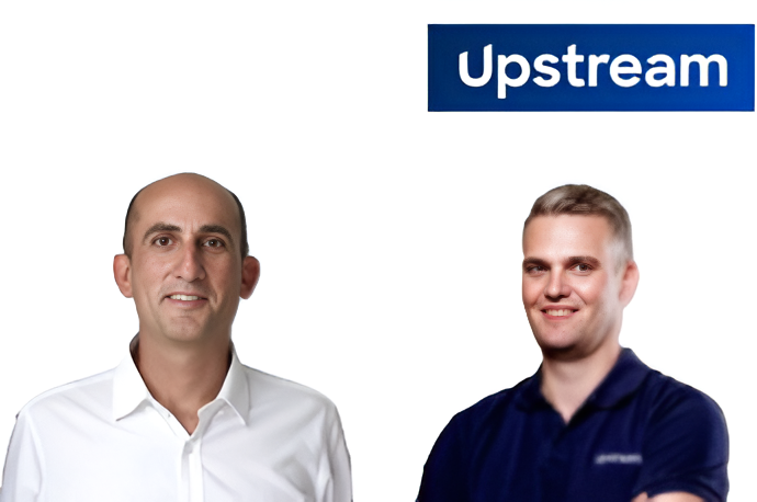 Two professional men smiling at camera with Upstream company branding