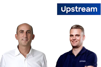 Two professional men smiling at camera with Upstream company branding