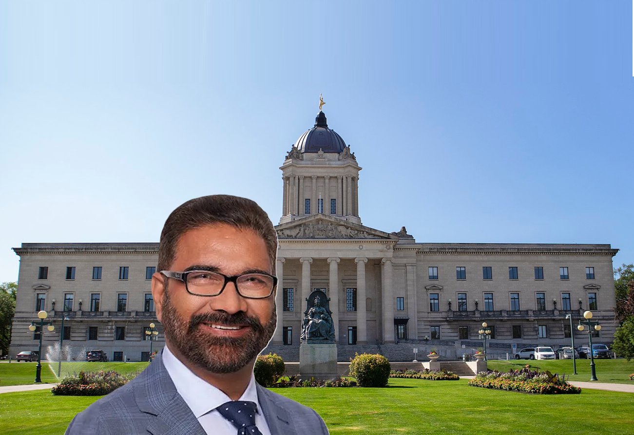 Professional man in glasses and suit smiling in front of Manitoba Legislative Building with dome and manicured grounds