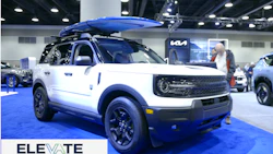 White and blue Kia EV9 SUV with roof rack displayed at Vancouver Auto Show event