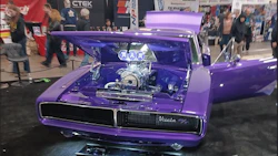 Purple custom car with open hood displaying chrome engine at automotive show