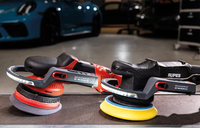 RUPES orbital sanders with red and yellow pads displayed in automotive workshop
