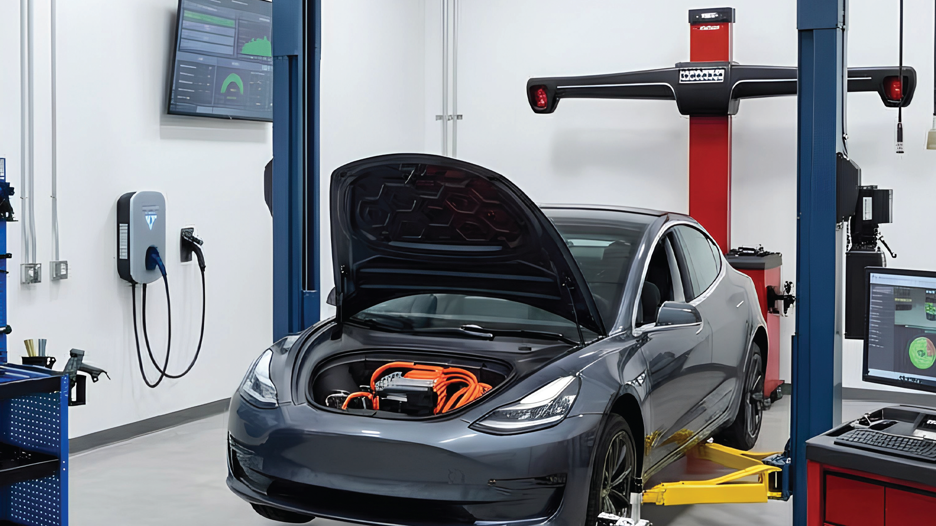 Tesla electric vehicle undergoing service in a modern automotive repair facility with diagnostic equipment and wheel alignment machine