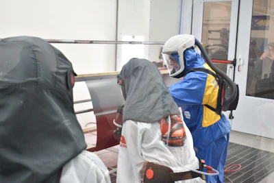 Rescue workers in protective gear and life vests assist a person during water safety training or emergency response operation