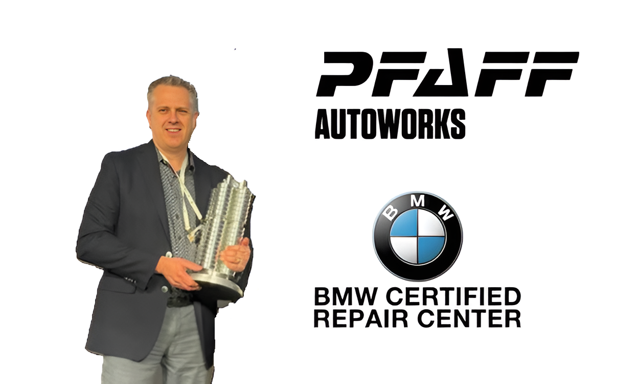 Professional man in suit holding award with PFAFF Autoworks and BMW Certified Repair Center logos