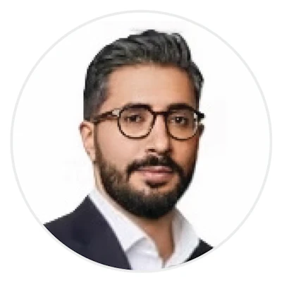 Professional headshot of a bearded man wearing glasses and dark blazer with white shirt