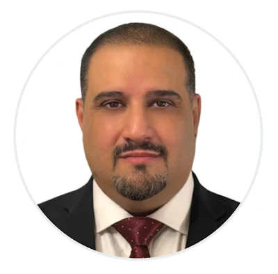 Professional headshot of a man in business attire with dark suit, white shirt, and burgundy tie
