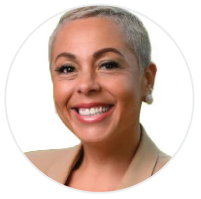 Professional headshot of a smiling woman with short gray hair wearing a beige top
