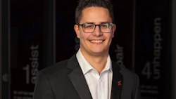 Professional man in glasses and dark blazer smiling at camera