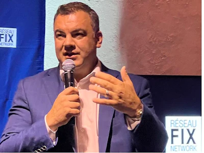 Professional man speaking at podium with microphone at RESEAU FIX branded event