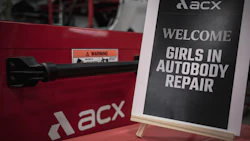 ACXS branded red equipment with welcome sign promoting girls in autobody repair program