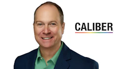 Professional headshot of smiling man in navy blazer and green shirt with Caliber branding