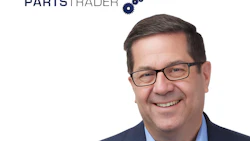 Professional headshot of smiling man in glasses and navy blazer with PartsTrader logo