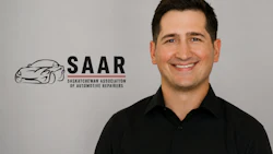 Professional headshot of smiling man in black shirt with SAAR automotive association logo background