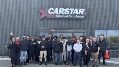 CARSTAR Collision & Glass Service team photo with employees standing outside facility entrance
