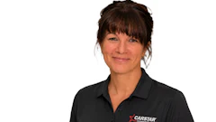 Professional woman wearing black CARSTAR polo shirt, smiling at camera against white background