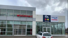 Commercial storefront with Fix Collision and Novus Glass signage on modern building facade