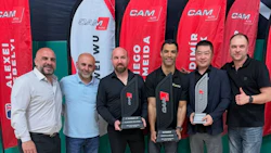 Six men posing at professional event with red CAM branded banners in background