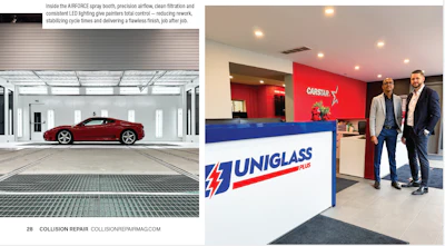 Modern automotive service facility reception desk with UNIGLASS and CARSTAR branding and two professionals standing at counter