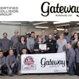 Gateway Autobody Ltd. team of approximately 20 employees posing together in an automotive repair shop holding certification documents