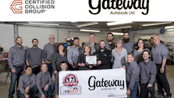 Gateway Autobody Ltd. team of approximately 20 employees posing together in an automotive repair shop holding certification documents