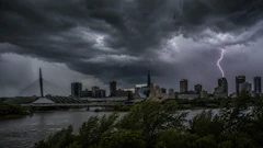 Dramatic thunderstorm over city skyline with lightning strike, cable bridge, and turbulent clouds