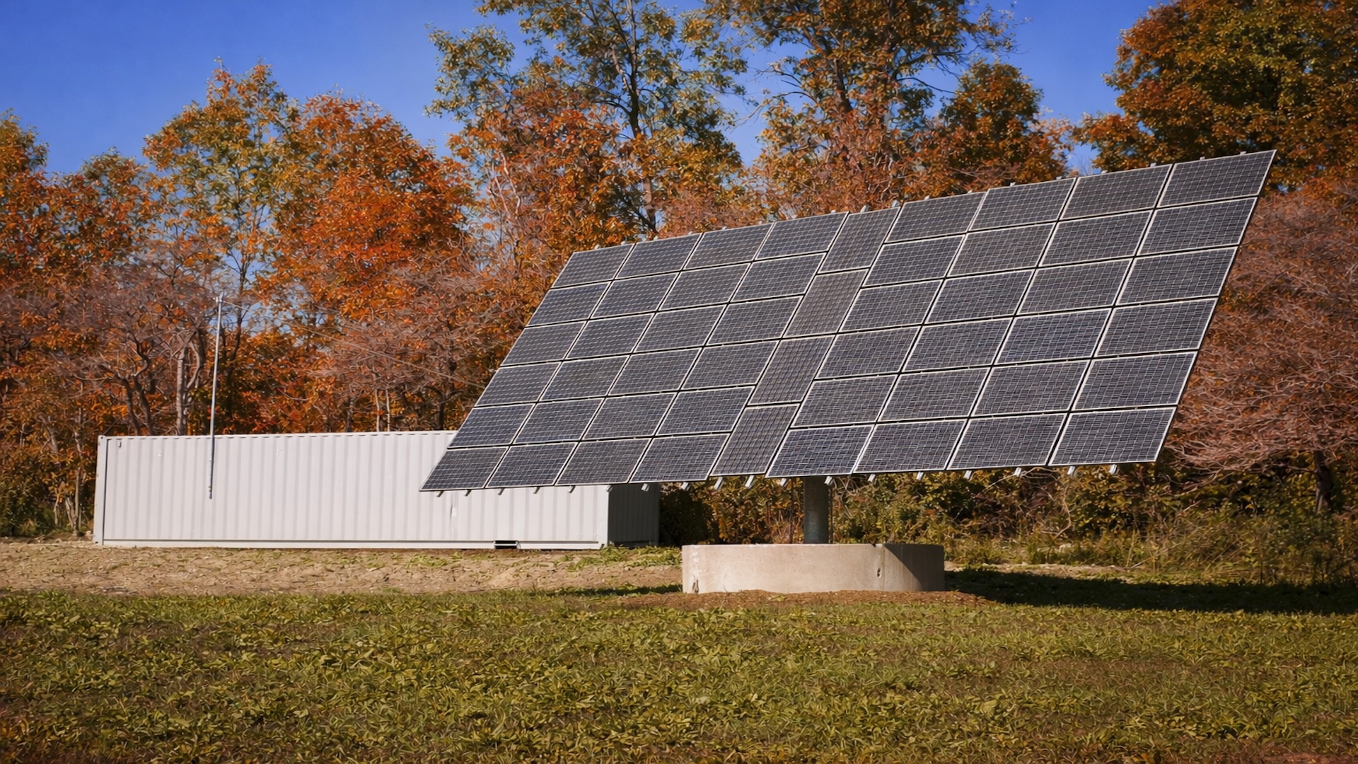 Large solar panel array mounted on white structure in autumn field with deciduous trees