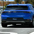 Blue Chevrolet Equinox electric SUV parked in urban lot with white sedan nearby
