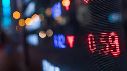 Digital stock market display with red LED numbers and city lights bokeh in background