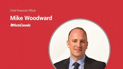 Mike Woodward, Chief Financial Officer at AutoCanada, professional headshot on red background