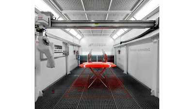 Modern automotive paint booth with red vehicle on lift, overhead crane system, and industrial workspace