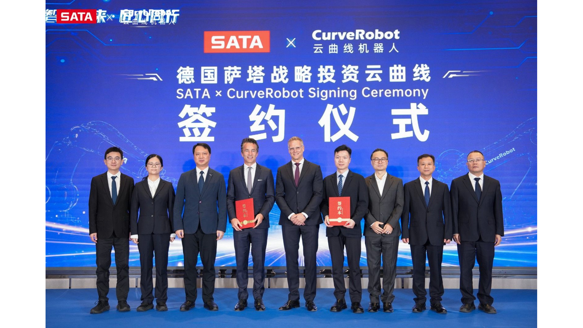 Ten business executives in formal attire holding red documents at SATA and CurveRobot signing ceremony