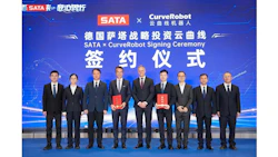 Ten business executives in formal attire holding red documents at SATA and CurveRobot signing ceremony
