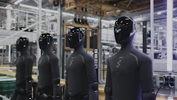 Row of black mannequins displayed in industrial warehouse setting with metal framework and equipment